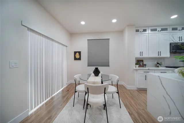 a kitchen with a dining table chairs and microwave