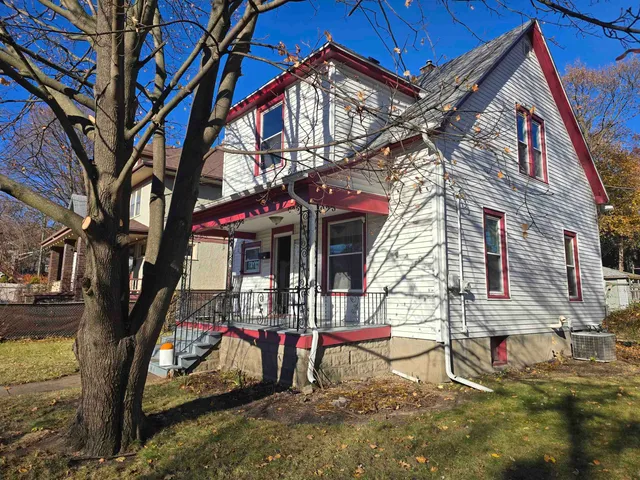 a view of a house with a yard and wooden fence