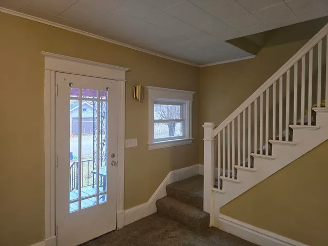 a view of entryway and hall with wooden floor