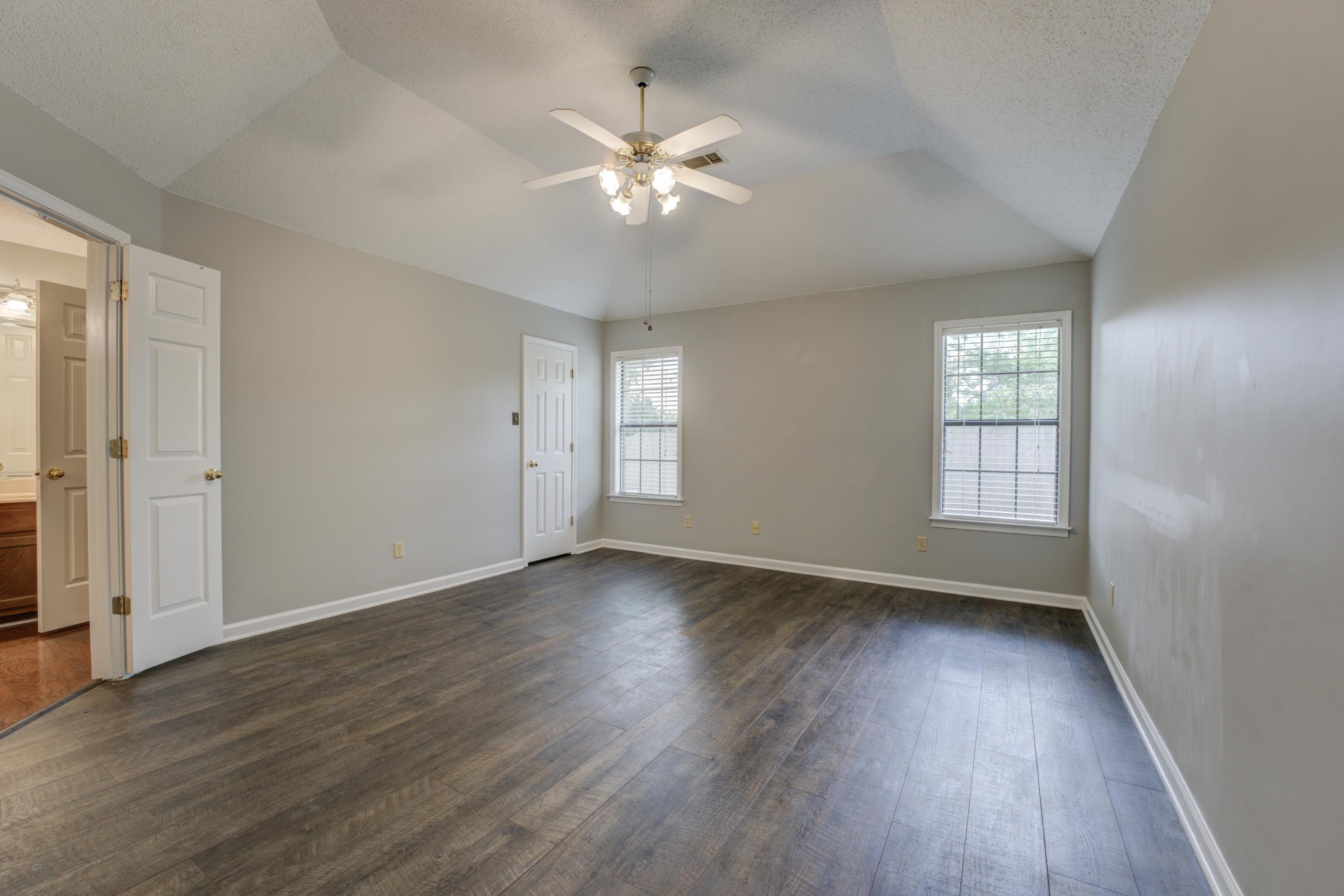 6387 St Elmo Road Bartlett, TN 38135 - Photo 12 of 30 Rest easy in the romantic primary bedroom with soaring ceiling, wood floors, walk-in closet and luxury bathroom.