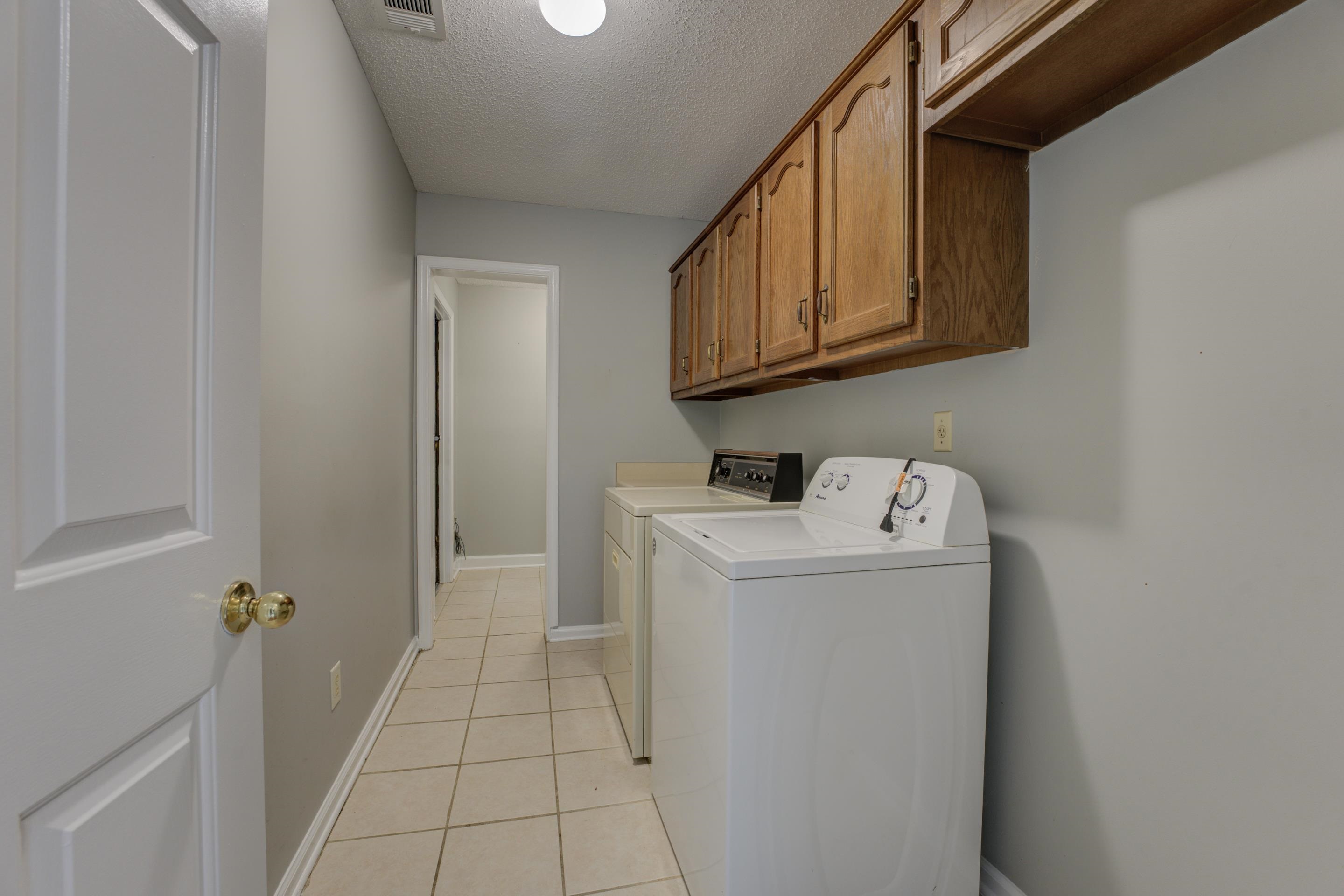 6387 St Elmo Road Bartlett, TN 38135 - Photo 23 of 30 Doing laundry will be a breeze in this laundry room with cabinets, washer and dryer.
