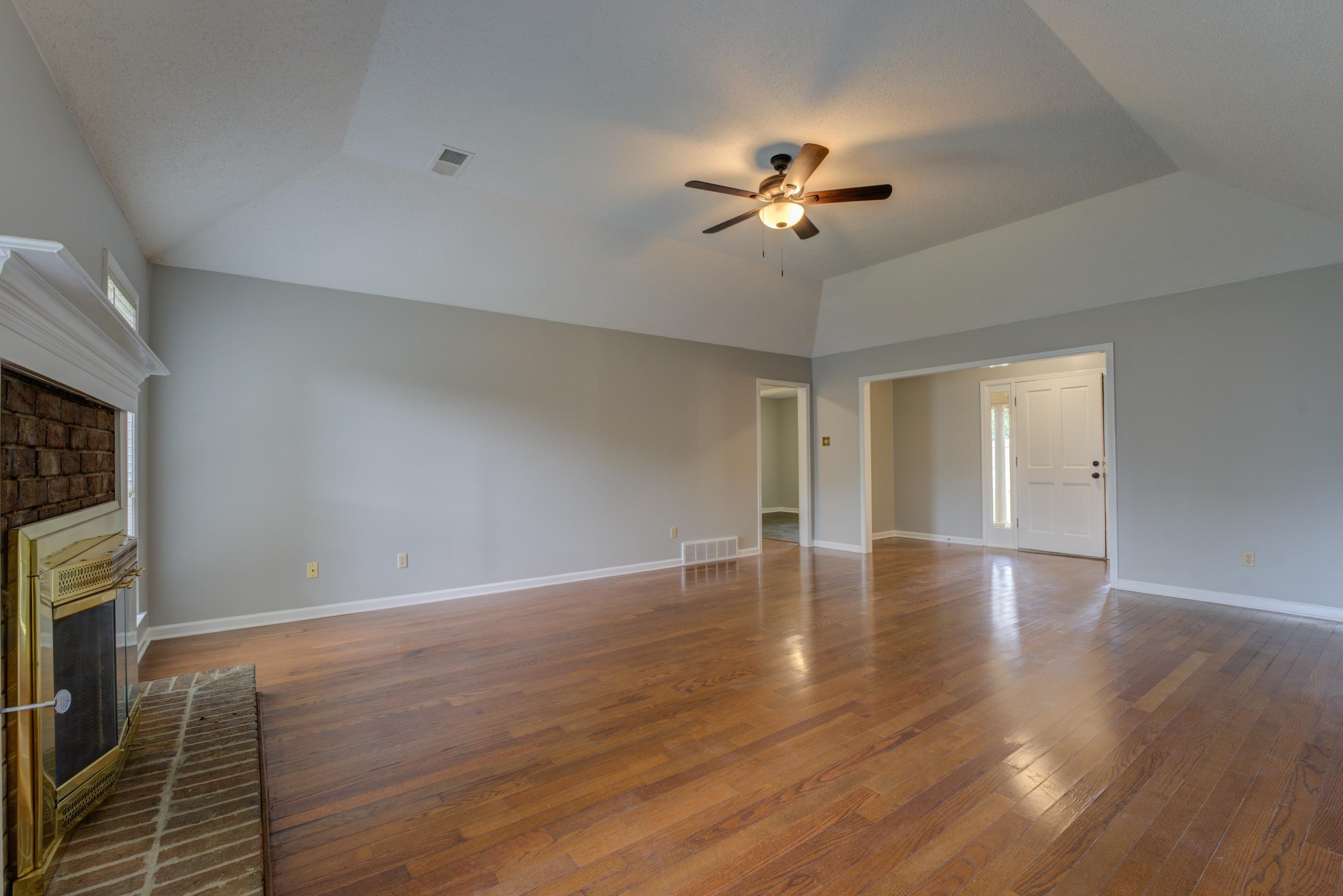 Spacious, warm and inviting great room with vaulted ceiling, wood floors and fireplace.