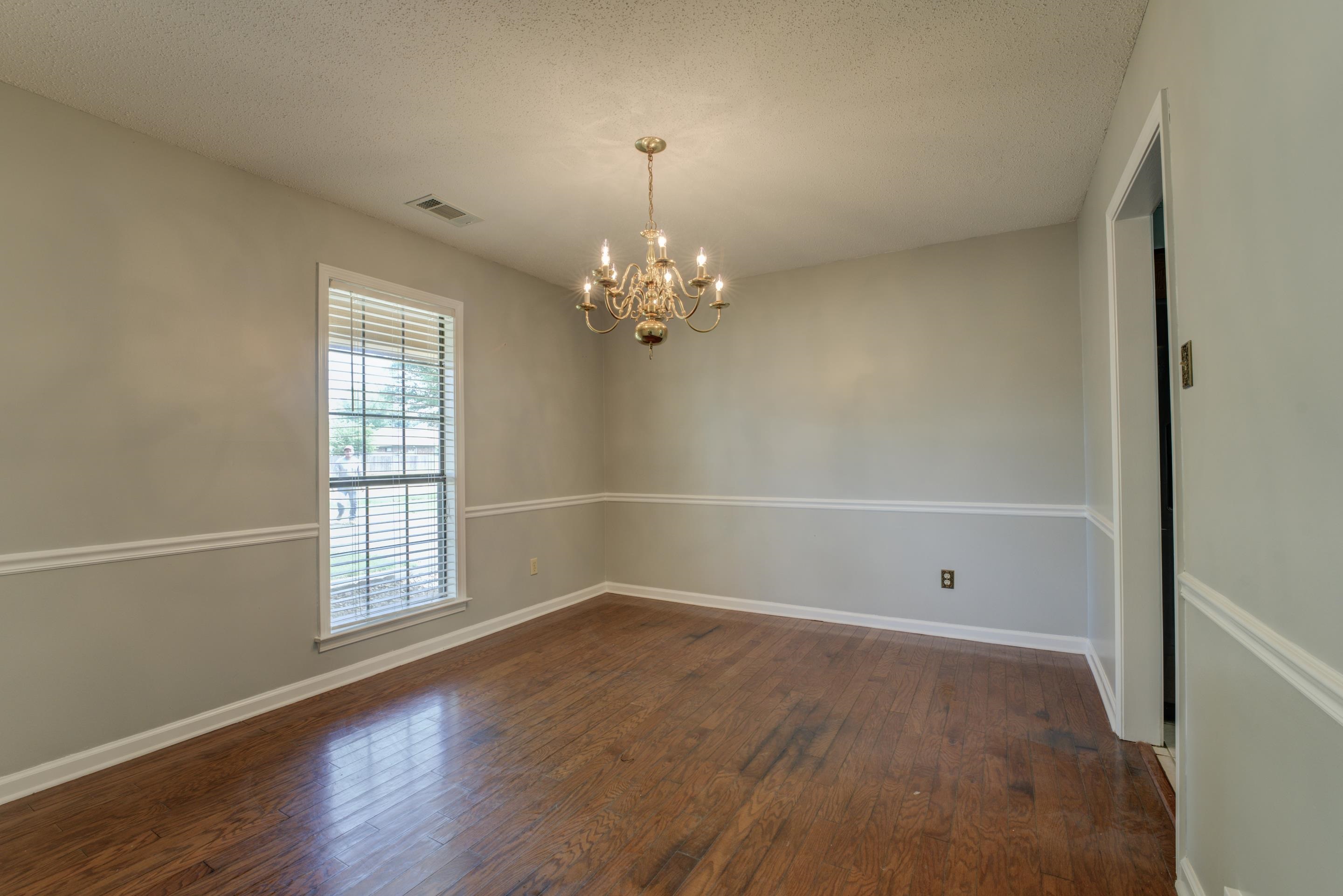 Entertain in the formal dining room with chair rail, wood floors and chandelier.