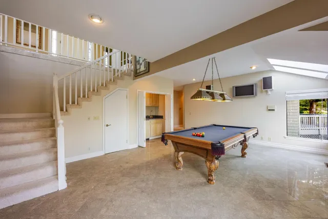 a room with pool table and windows