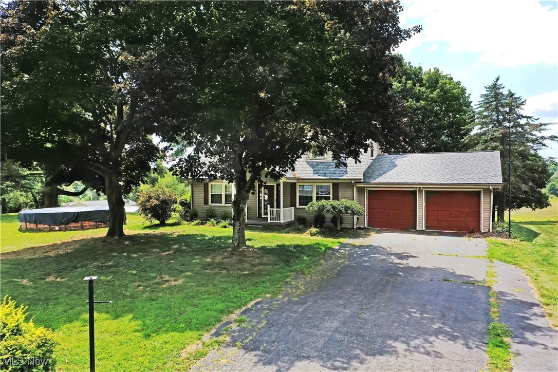 1141 Howell Road East Palestine, OH 44413 - Photo 3 of 41 View of front of house with a front yard, asphalt driveway, a garage, and a shingled roof