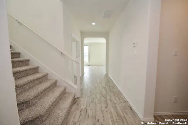 a view of a hallway with wooden floor and staircase