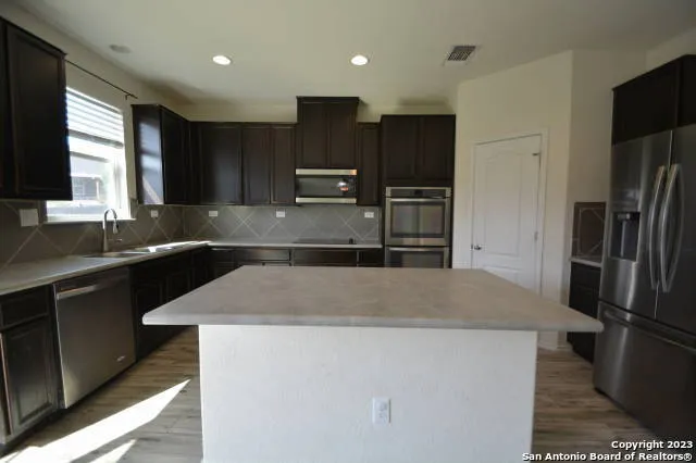 a kitchen with stainless steel appliances a refrigerator sink and microwave