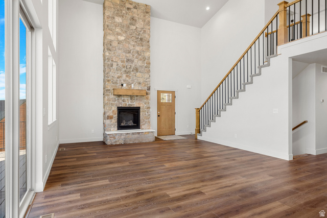 1159 North Broad Hollow Road Garden City, UT 84028 - Photo 10 of 55 Spacious living area featuring a floor-to-ceiling stone fireplace with a wood mantel, rich wood-finish flooring, and expansive windows
