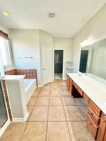 a spacious bathroom with a mirror and a shower