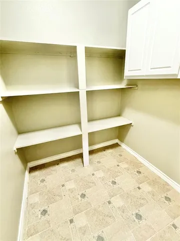 a white room with a wooden floor and cabinet