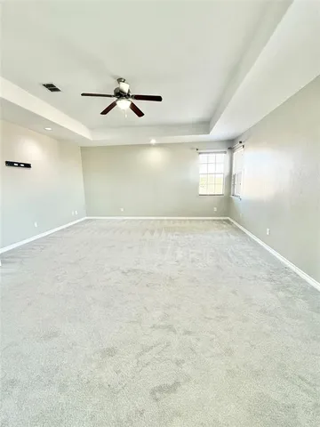 an empty room with windows and fan view