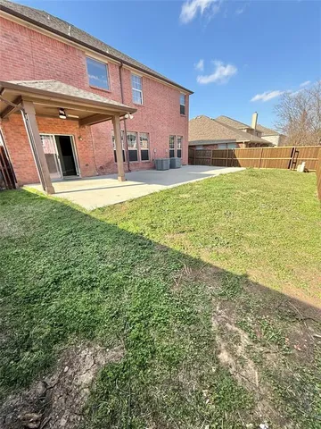 a view of a backyard with table and chairs under an umbrella