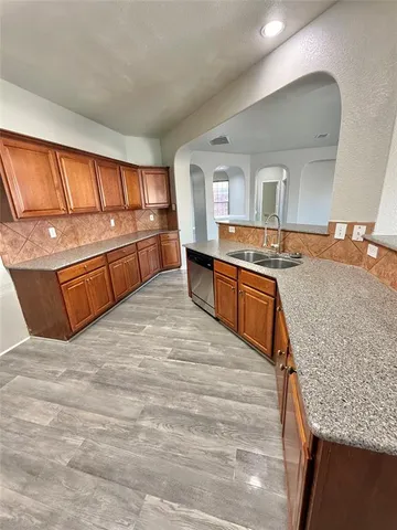 a kitchen with stainless steel appliances granite countertop a sink stove and cabinets