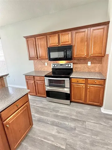 a kitchen with stainless steel appliances granite countertop a stove a sink and a refrigerator