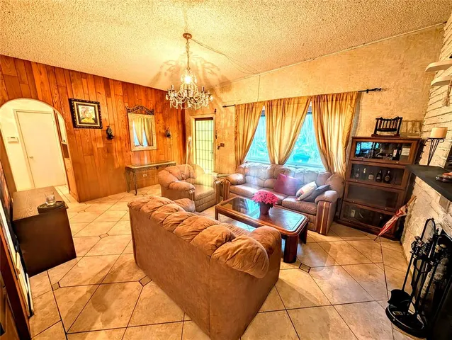 a living room with furniture a flat screen tv and a floor to ceiling window