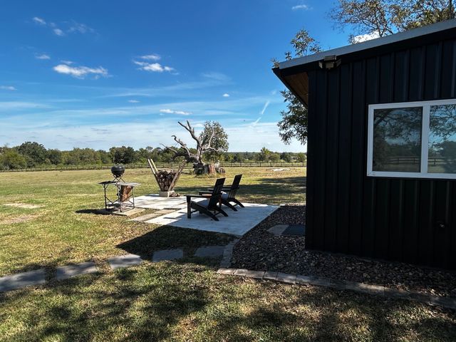 a view of a house with backyard and sitting area