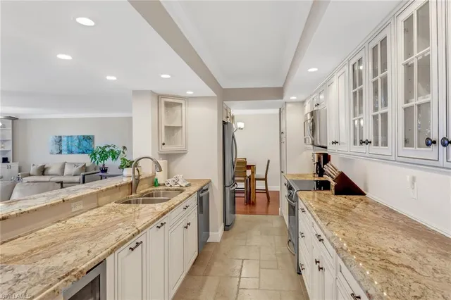 a large kitchen with granite countertop a sink and dishwasher with a large kitchen island