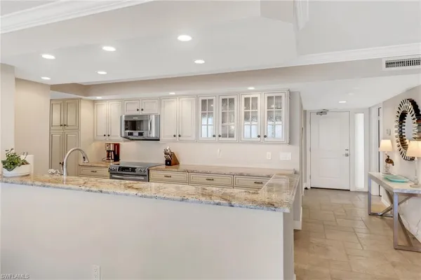 a view of a kitchen with kitchen island a counter top space cabinets and stainless steel appliances