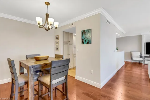 a view of a dining room with furniture wooden floor and chandelier