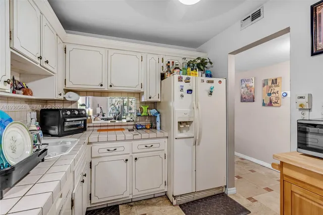 a kitchen with stainless steel appliances a refrigerator sink and cabinets