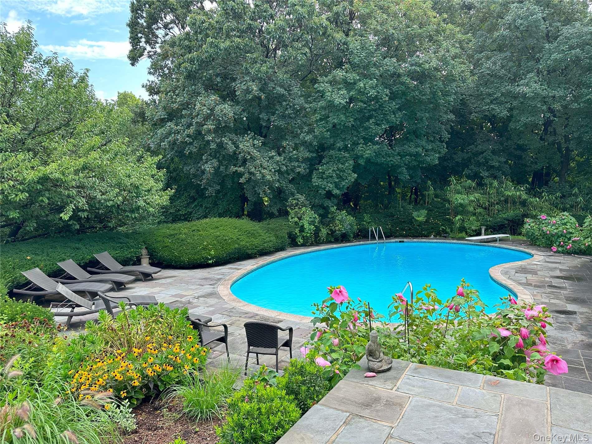 120 West Creek Farms Road Sands Point, NY 11050 - Photo 21 of 36 a view of a swimming pool with an outdoor seating area and garden