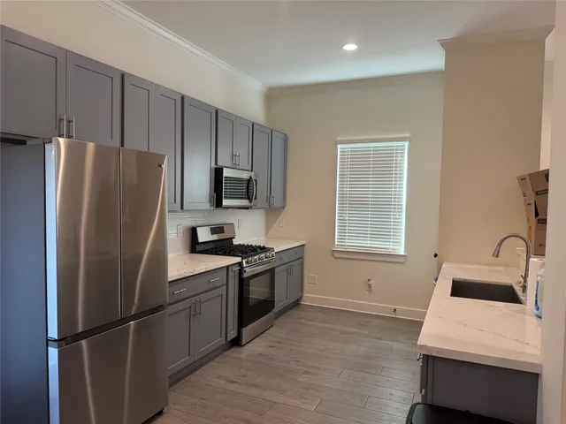 a kitchen with wooden cabinets and stainless steel appliances