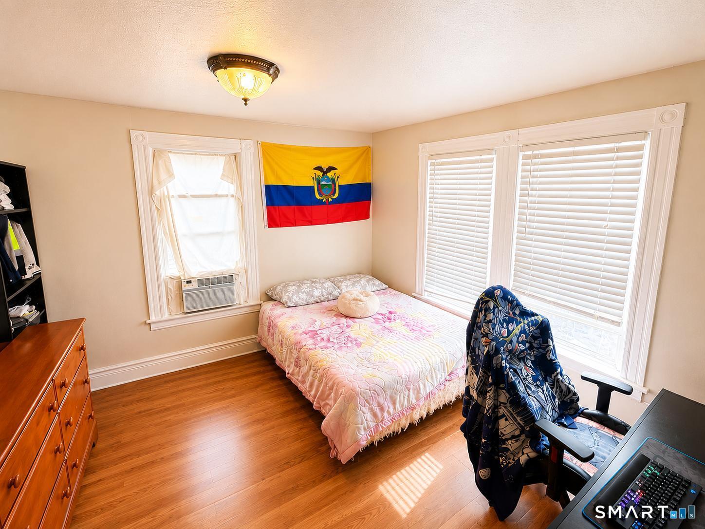 98 Huntington Road Bridgeport, CT 06608 - Photo 9 of 15 a bedroom with a bed a dresser with wooden floor