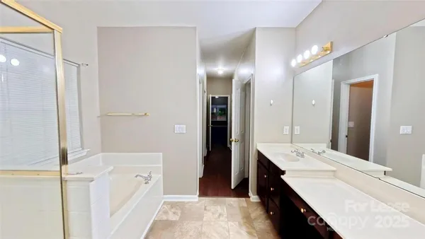 a bathroom with a double vanity sink a mirror and a shower