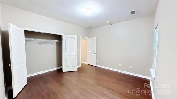 an empty room with wooden floor and closet