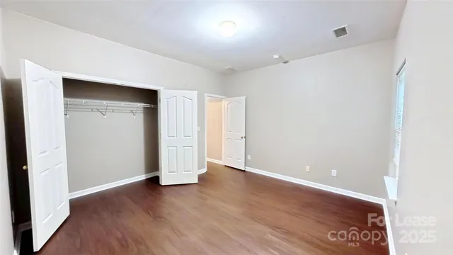an empty room with wooden floor and closet