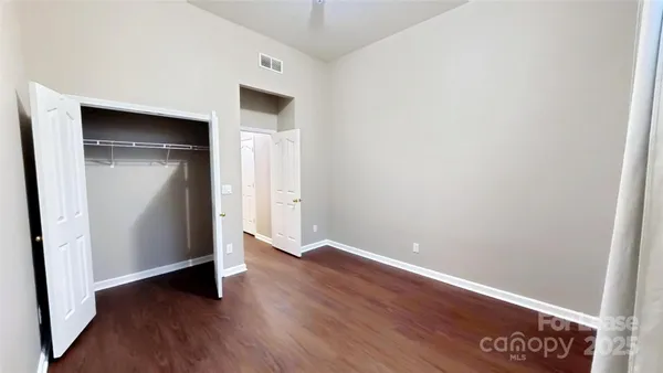 an empty room with wooden floor and closet
