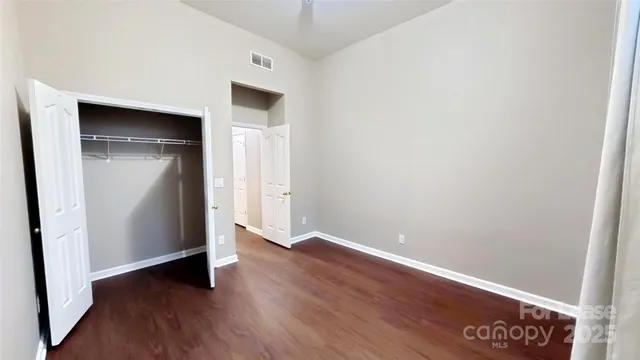 an empty room with wooden floor and closet