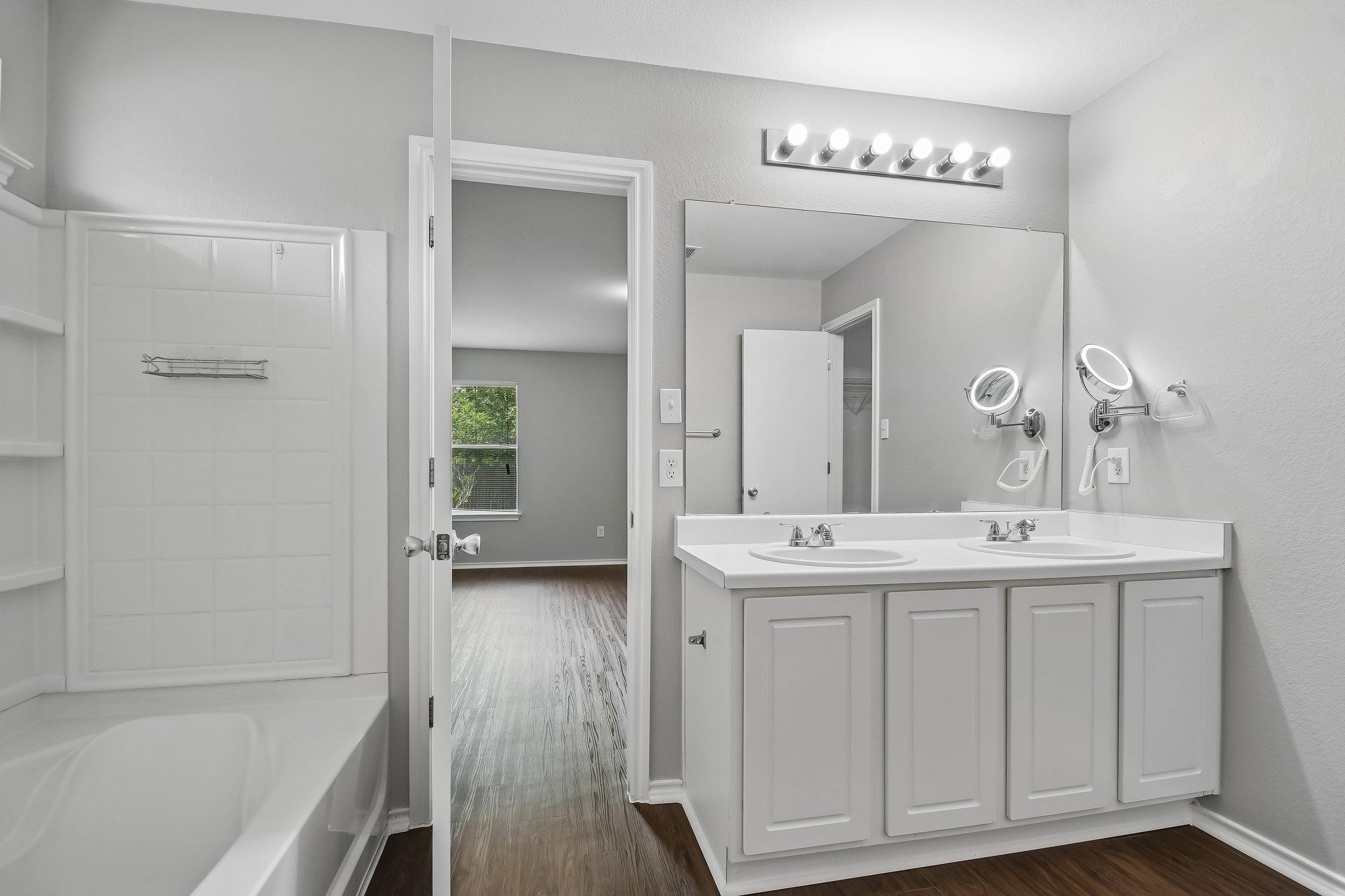 610 Lavaca Loop Elgin, TX 78621 - Photo 21 of 37 Double vanity sinks and a large mirror illuminate this well-appointed bathroom with durable flooring.