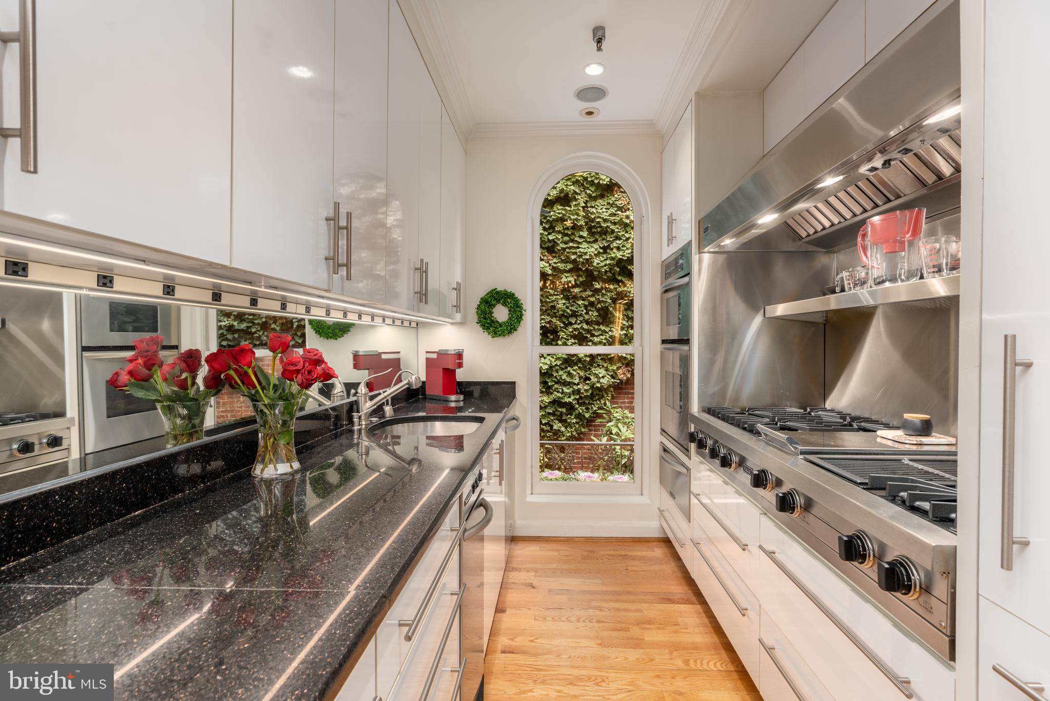 3070 Q Street Northwest Washington, DC 20007 - Photo 12 of 33 a kitchen with stainless steel appliances kitchen island granite countertop a stove a sink and a microwave
