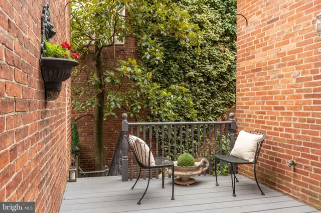 a balcony with wooden floor and outdoor seating