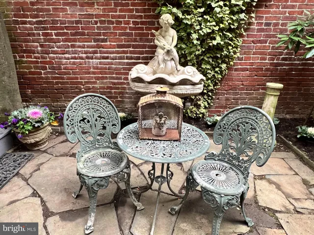 a vase of flowers sitting on a table in a patio