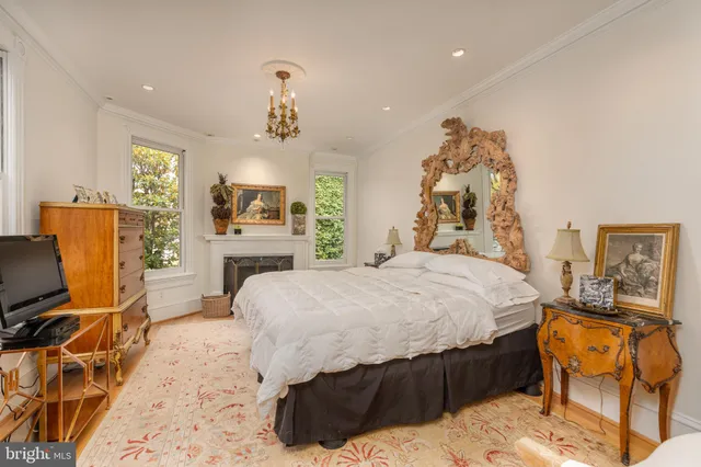 a spacious bedroom with a bed and dresser with mirror