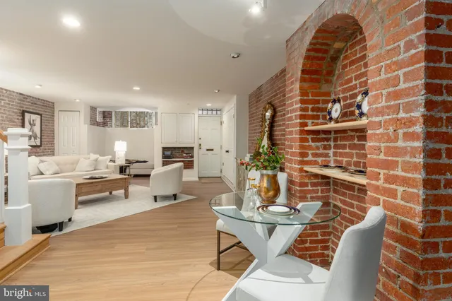 a living room with patio furniture and a dining table with wooden floor