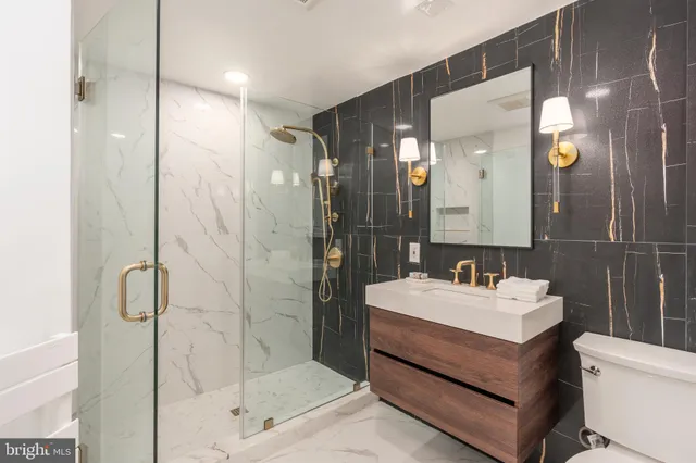 a bathroom with a sink mirror and shower