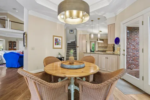 a room with kitchen island granite countertop white cabinets and chandelier