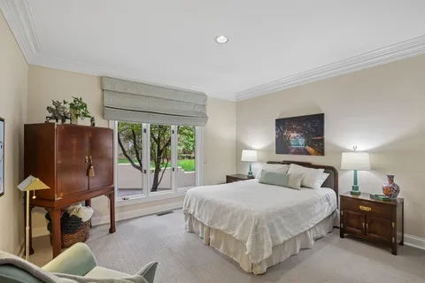 a spacious bedroom with a bed and a chandelier