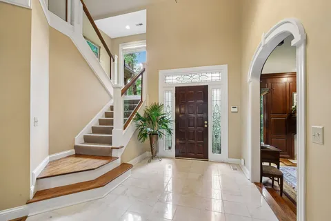 a living room with furniture a dining table and a piano table with wooden floor