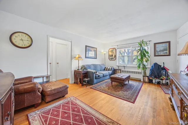 a living room with furniture a rug a window and a lamp
