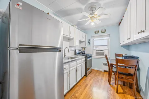a kitchen with stainless steel appliances a stove a refrigerator cabinets and a dining table