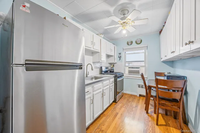 a kitchen with stainless steel appliances a stove a refrigerator cabinets and a dining table