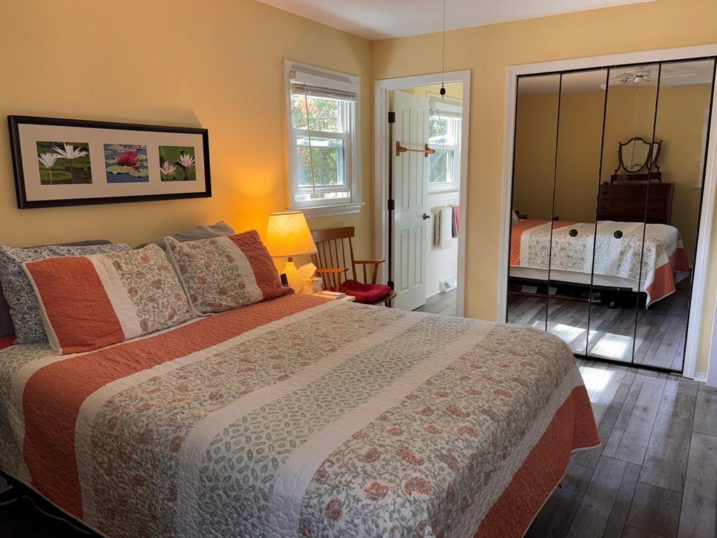 112 Clay Pond Road Bourne, MA 02532 - Photo 17 of 39 a bedroom with a large bed and wooden floor