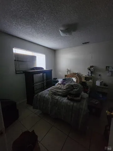 a bed sitting in a room next to a lamp