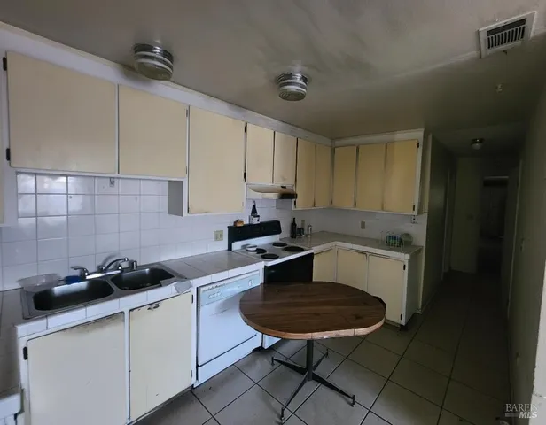 a kitchen with a sink a stove a refrigerator and cabinets