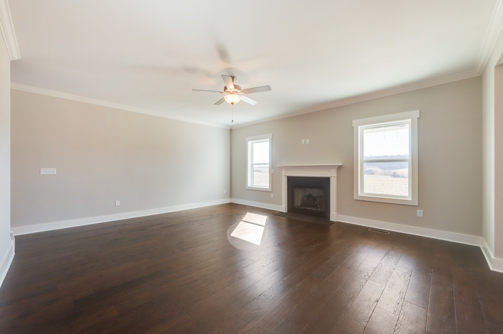 575 Flippen Road Lebanon, TN 37087 - Photo 11 of 14 an empty room with wooden floor fireplace and windows