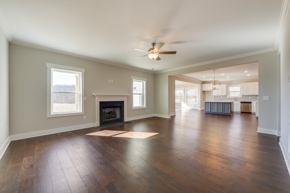 575 Flippen Road Lebanon, TN 37087 - Photo 5 of 14 an empty room with wooden floor fireplace and windows